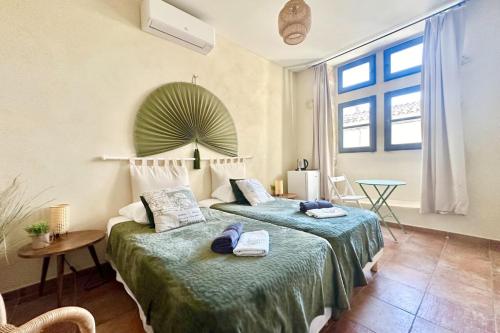 a bedroom with two beds and a table and windows at Maison Cosy Lodge 15 p clim wifi cour garage in Montfrin