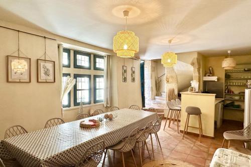 une cuisine et une salle à manger avec une table et des chaises dans l'établissement Maison Cosy Lodge 15 p clim wifi cour garage, à Montfrin