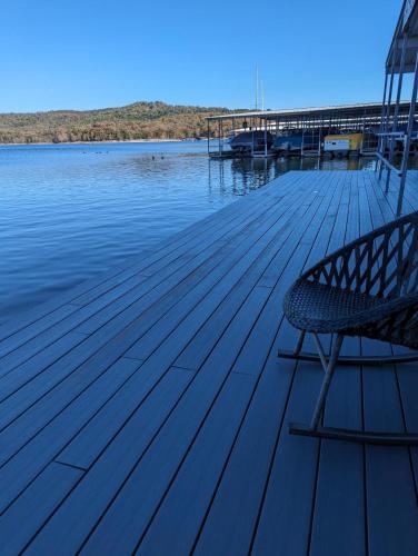 a bench sitting on a dock next to the water at Lighthouse Lodge - 1 bedroom Lake View - 15 Min to in Kimberling City