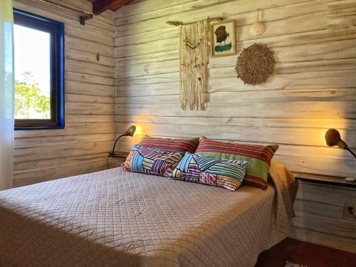 a bedroom with wooden walls and a bed with two pillows at Angelo in Punta Del Diablo