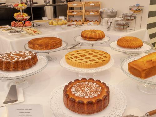 a table with cakes and other desserts on plates at Hotel San Pietro Palace in Finale Ligure
