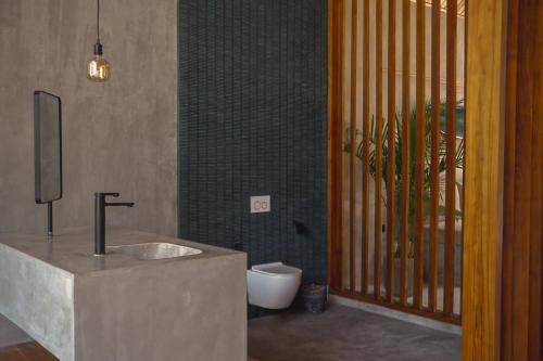 ein Badezimmer mit Waschbecken und Toilette in der Unterkunft Karang Villas Uluwatu in Uluwatu