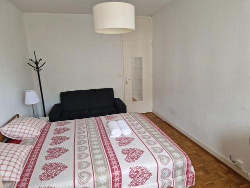 a bedroom with a bed and a black chair at Room in Shared Apartment Geneva in Geneva