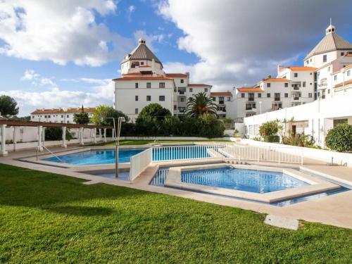 a pool in front of a large white building at Vilamoura Marina Apartment by Stay ici in Vilamoura