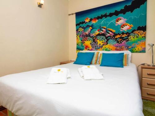 a bedroom with a white bed with a painting on the wall at Vilamoura Marina Apartment by Stay ici in Vilamoura