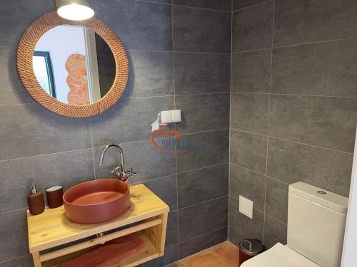 ein Badezimmer mit einem Kupferwaschbecken und einem Spiegel in der Unterkunft Monte Gerações - Complete House - Heated pool - Typical Algarvian - close to Quinta Lago Vale Lobo and Vilamoura in Almancil