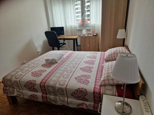 a bedroom with a bed with a lamp and a desk at Room in Shared Apartment Geneva in Geneva