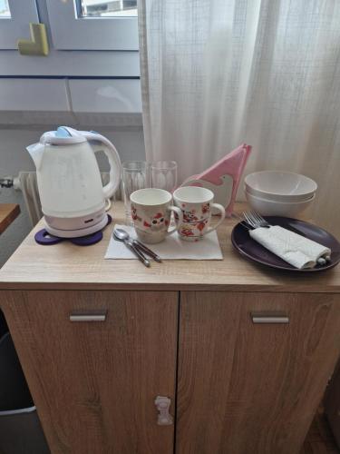 a counter with two cups and a tea pot on it at Room in Shared Apartment Geneva in Geneva