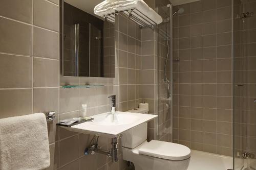 a bathroom with a sink and a toilet and a mirror at Hotel Imaz in Segura