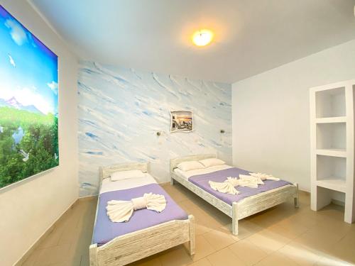 two beds in a room with a painting on the wall at Anastasia villa in Emporio Santorini