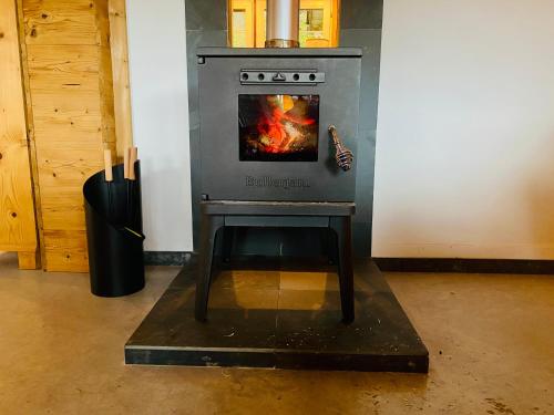 a stove in a room with a fire in it at Birkenhof, Haus Märli in Herisau
