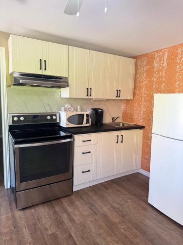 a kitchen with white cabinets and a stove top oven at Lincoln Inn Fredericton in Fredericton
