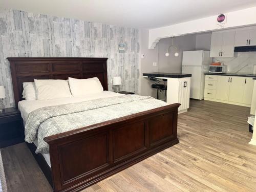 a bedroom with a large bed and a kitchen at Lincoln Inn Fredericton in Fredericton