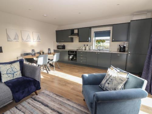 a kitchen and living room with a couch and chairs at The Boathouse in Kilkee