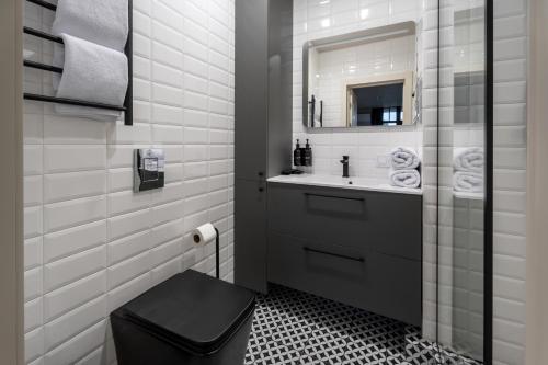 a bathroom with a black toilet and a sink at Ridge Apartments in Chernivtsi