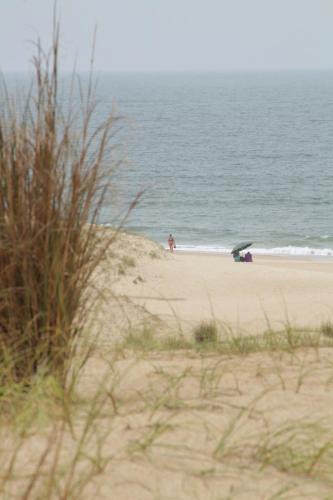 a beach with people on the sand and the ocean at Angelo in Punta Del Diablo