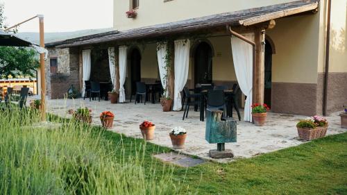 a patio of a house with chairs and tables at Podere Scoldasu - Minerva in Massa Marittima