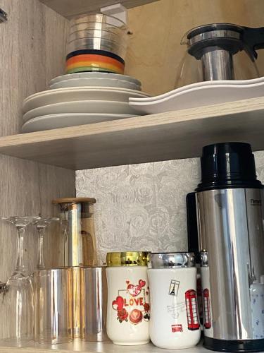 a kitchen shelf with jars and other items on it at HA LUXURY STUDIO SUITE 2 buziga in Gaba