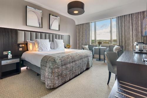 a hotel room with a bed and a desk and a room at Fota Island Hotel and Spa in Fota Island