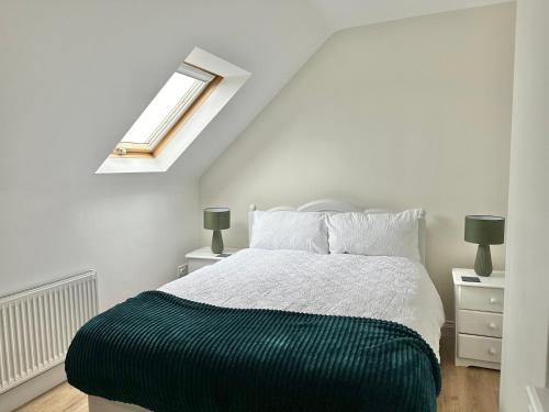 Relax in Spacious Style with Stunning Views- Drim Cottage في Malin Head: غرفة نوم بيضاء مع سرير ونافذة