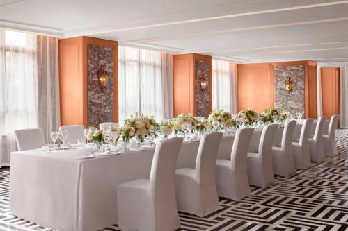 a long table in a room with white chairs and flowers at The St. Regis Shanghai Jingan in Shanghai