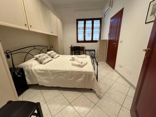 a bedroom with a bed with white sheets and a window at Lovely Guesthouse QSE in Quartu SantʼElena