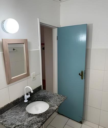 a bathroom with a sink and a blue door at Casa da Lua Buzios in Búzios