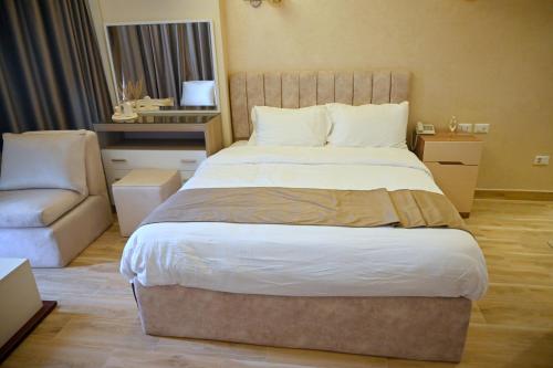 a bedroom with a large bed and a couch at Pyramids Wonders Hotel in Cairo