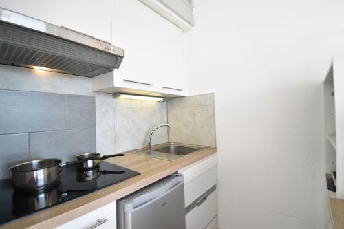 - une cuisine avec 2 casseroles et un évier dans l'établissement Point d'or B - Hossegor agréable studio en duplex situé dans une résidence avec piscine en bord de plage, à Soorts-Hossegor
