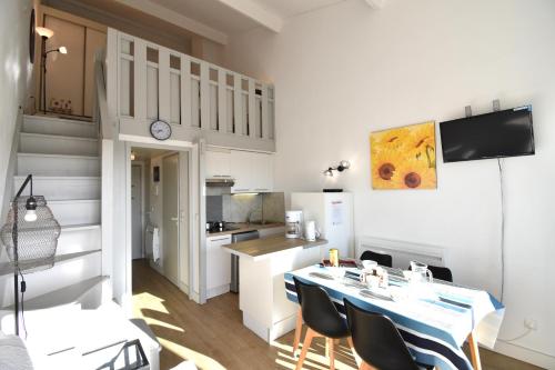 une cuisine avec une table et des chaises dans une pièce dans l'établissement Point d'or B - Hossegor agréable studio en duplex situé dans une résidence avec piscine en bord de plage, à Soorts-Hossegor