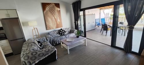 a living room with a couch and a table at El Bungalow in Playa Fañabe
