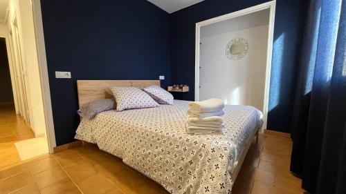 a bedroom with a bed with blue walls at La Caseta in Ulldemolins