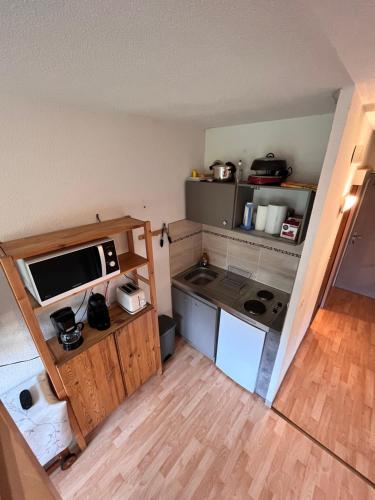 a small kitchen with a stove and a microwave at Studio au pied des pistes in Montferrier