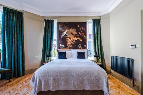 a bedroom with a large bed with green curtains at Tilstone Boutique Guest Accommodation in Llandudno