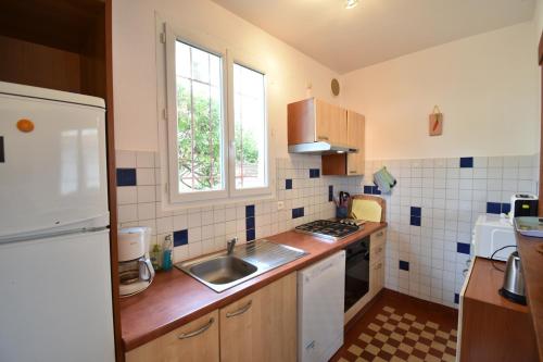 une petite cuisine avec un évier et une fenêtre dans l'établissement 1451 TCF - Hossegor villa plain pied en bordure du lac marin avec agréable vue sur le lac et située à environ 1000m du centre ville, à Soorts-Hossegor