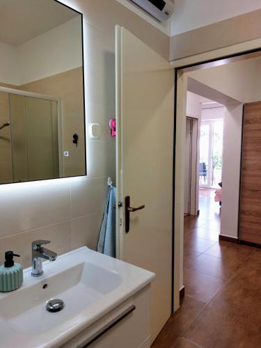 a bathroom with a sink and a mirror at Tangerine Apartment in Rabac