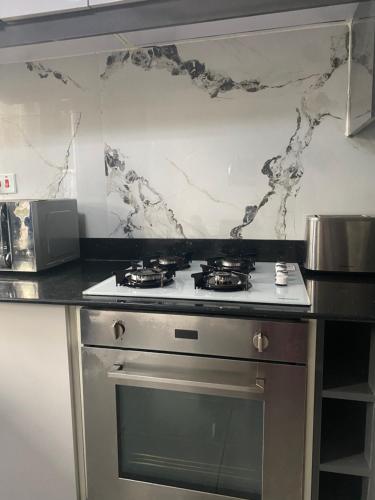 a kitchen with a stove and a counter top at HA LUXURY TWO BEDROOMED Munyonyo in Gaba