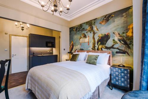 a bedroom with a large bed with a painting on the wall at Tilstone Boutique Guest Accommodation in Llandudno