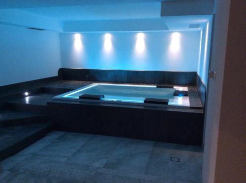 a swimming pool in a room with blue lights at Hotel Silvana in Selva di Val Gardena