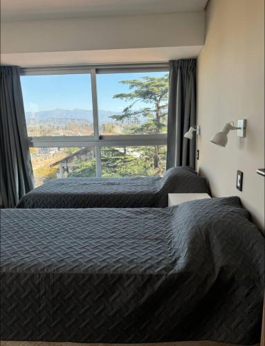 een slaapkamer met twee bedden en een groot raam bij Excelente Dpto, Gran vista MDZ in Mendoza