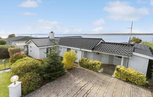 an exterior view of a house with a driveway at Lovely Home In Ølsted With Kitchen in Ølsted