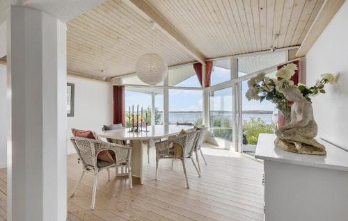 a dining room with a table with a vase of flowers at Lovely Home In Ølsted With Kitchen in Ølsted