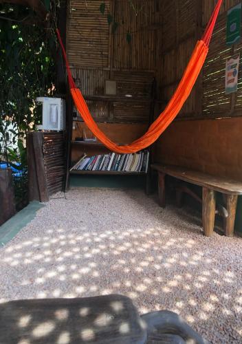an orange hammock in a room with a bench at Espaço Shanti - Chalés in Sao Jorge