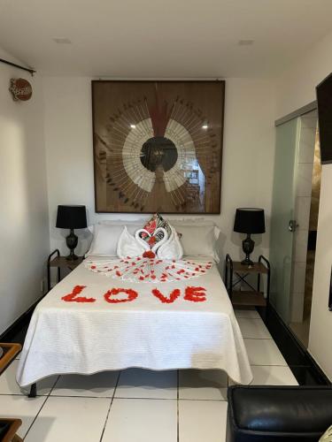 a bedroom with a bed with red decorations on it at Flor de Limão Hotel Boutique in Coroa Vermelha