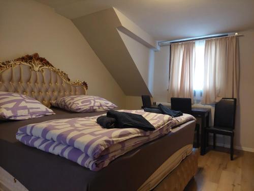 a bedroom with a bed with a headboard and a window at Hotel Bruchsal Herz in Bruchsal