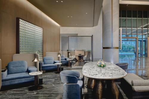 a lobby with a table and blue chairs and a table at Crowne Plaza Kunshan East by IHG in Kunshan