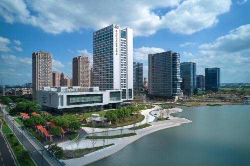 a city with tall buildings and a body of water at Crowne Plaza Kunshan East by IHG in Kunshan