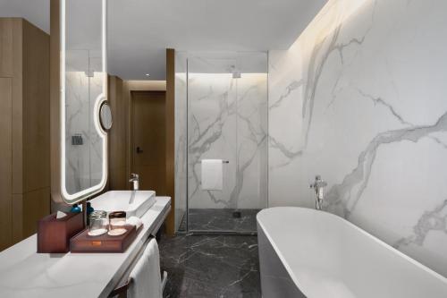 a bathroom with a tub and a sink and a shower at Crowne Plaza Kunshan East by IHG in Kunshan