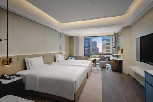 a hotel room with two beds and a flat screen tv at Crowne Plaza Kunshan East by IHG in Kunshan