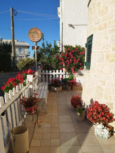 a patio with flowers and a white fence and benches at Trullo Di Tagaro in Locorotondo